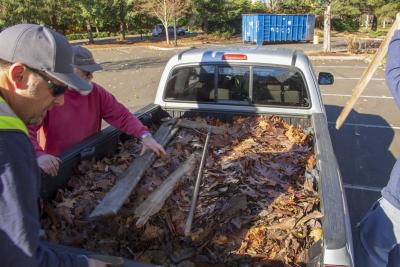 People getting ready to unload leaves from a flated truck